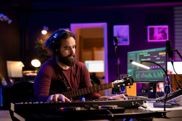 Skilled artist musician composing a song and playing his guitar, acoustical engineering techniques...