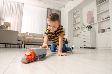 Little boy playing with toy car at home, low angle view © New Africa