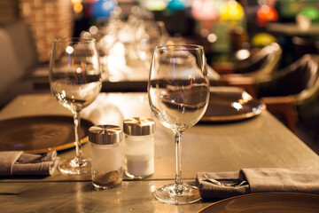 Elegant restaurant table setting with wine glasses and warm ambient lighting