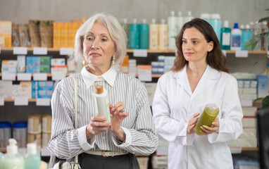Senior woman select shampoo in pharmacy, examine packaging. Health care, healthy lifestyle,...