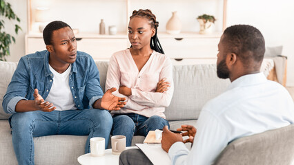 Marriage Therapy Session. Black couple speaking to family counselor about relationship problems,...