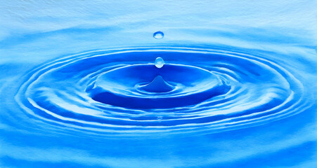Blue water drop splashing in a calm pool, symbolizing purity in watercolor
