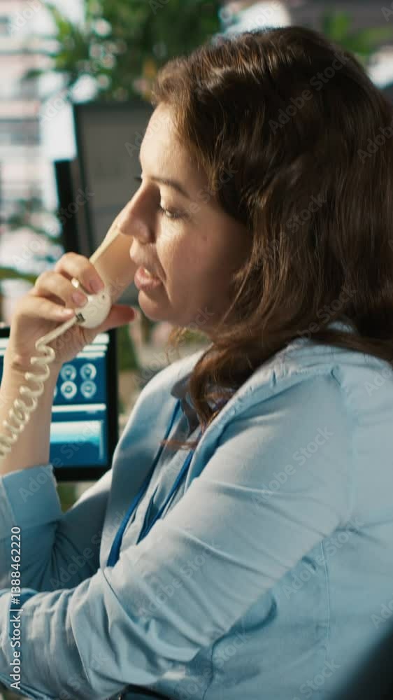 Poster vertical video worker in office using landline phone to talk with client while reviewing charts. emp