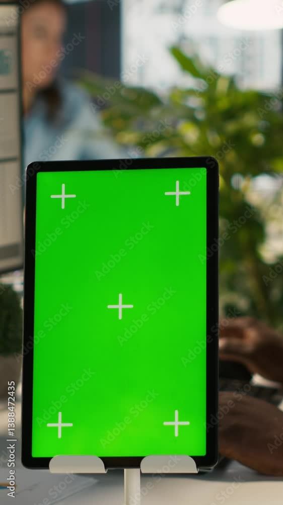 Poster vertical video close up of green screen tablet in front of employee checking progress done on projec