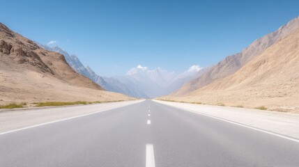 A long, straight highway stretches towards snow-capped mountains under a clear blue sky. The road is flanked by tan, arid hillsides. The image is high-quality, with sharp details and bright lighting.