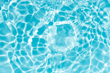 Blue water with ripples on the surface. Defocus blurred transparent blue colored clear calm water surface texture with splashes and bubbles. Water waves with shining pattern texture background.