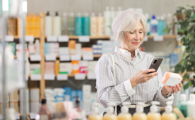 Elderly woman in summer clothes scans code on package of pills to check the expiration date