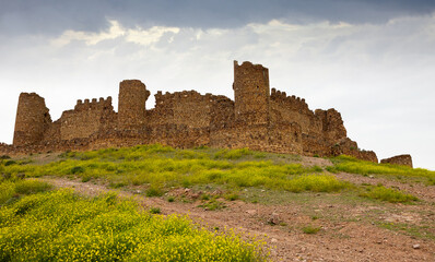 Obraz premium Dramatic view of ruined Almonacid de Toledo at Spanish province of Toledo castle at cloudy spring day