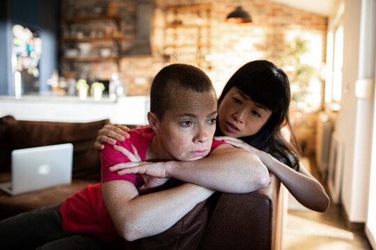 Lesbian couple comforting each other during emotional moment at home