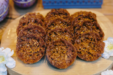 Round cookies with chocolate-covered nuts in a shop window.