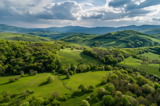 Lush green hills and valleys under a dramatic sky in the countryside during late afternoon sunlight