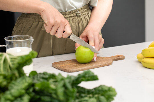Healthy cooking with fresh fruit, cutting green apples on a cutting board