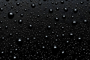 Obraz premium Close-up of water droplets on a dark surface, creating a serene and calming aesthetic perfect for nature-themed projects.