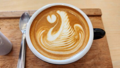 Beautiful Latte Art Design in Coffee Cup on Wooden Table Surface
