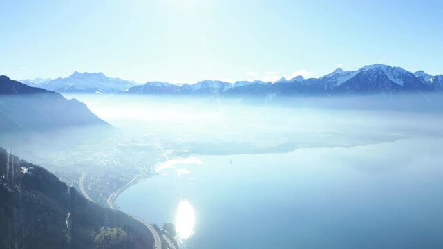 Establishing drone shot of landscape from Caux Palace Hotel of Lake Geneva and Dents du Midi mountain range in Caux, canton of Vaud, Switzerland