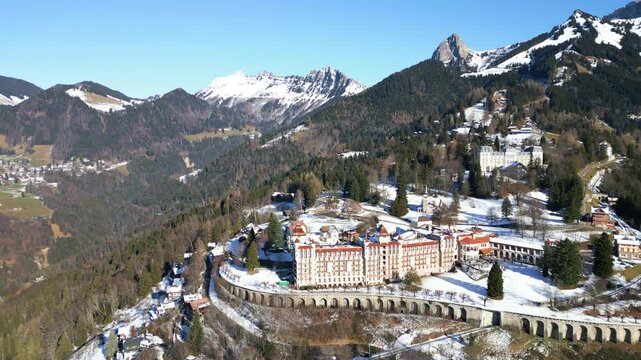 Dolly out drone shot of Caux Palace Hotel with snow during the day in the village of Caux, canton of Vaud, Switzerland
