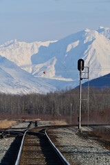 Tracks for the Alaska Railroad lead to the rugged, snow-capped mountains.
