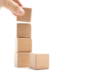 Hand holding wooden cubes stacked Isolated on white background. Copy Space. Business, Creative or Idea Template.