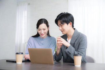 オフィスで女性の先輩上司に相談や企画や提案ををし会話する新人の男性社員の男女ビジネスイメージ