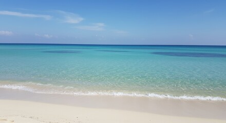 Fototapeta premium Serene Tropical Beachscape: Azure Waters Meet White Sands Under a Clear Sky