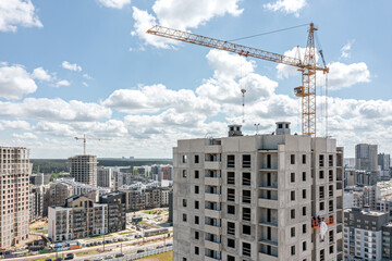 Fototapeta premium apartment buildings under construction and crane on residential area background. aerial drone photo.