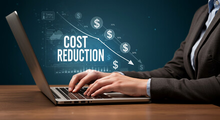 A person analyzing cost reduction with a red arrow and coins on a wooden table with blocks spelling cost png