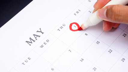 Red circle marked on a calendar at 1 of May as symbol of important day
