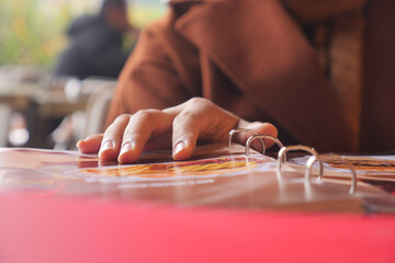 Fototapeta premium Hand reaching for a menu at a cafe on a sunny afternoon