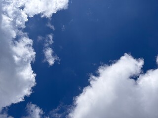 Beautiful blue sky with white clouds. The sky was clear and bright, and clouds were scattered all over the sky. The scene was peaceful and serene, as if the viewer was gazing at a beautiful day.