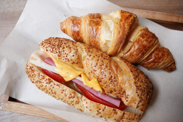 Freshly baked croissant and sandwich filled with ham and cheese