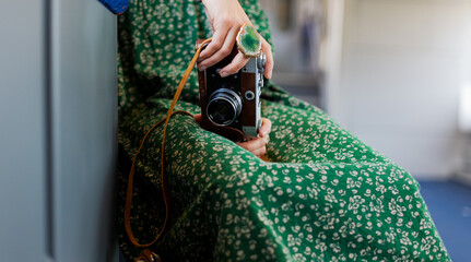 Train passenger. Stylish girl with camera in her hands enjoys train ride. Train travel.