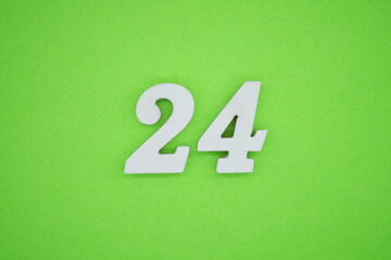 The numbers are made of white painted wood placed on a green paper background.
