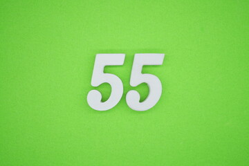 The numbers are made of white painted wood placed on a green paper background.