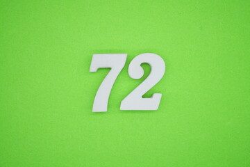 The numbers are made of white painted wood placed on a green paper background.