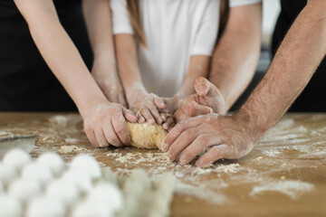 Caucasian family bonding through cooking activity, kneading dough with children and adults together