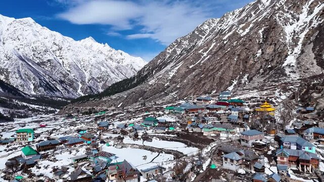 Aerial drone shot displaying the mesmerizing winter charm of Chitkul, where snow-laden rooftops and frozen fields create a postcard-perfect scene.