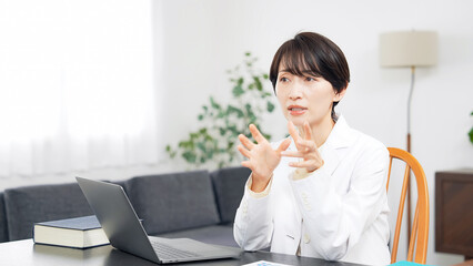 Obraz premium デスクのノートパソコンで作業する女性