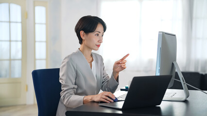 暗いオフィスでパソコンを使って作業する女性ビジネスパーソン