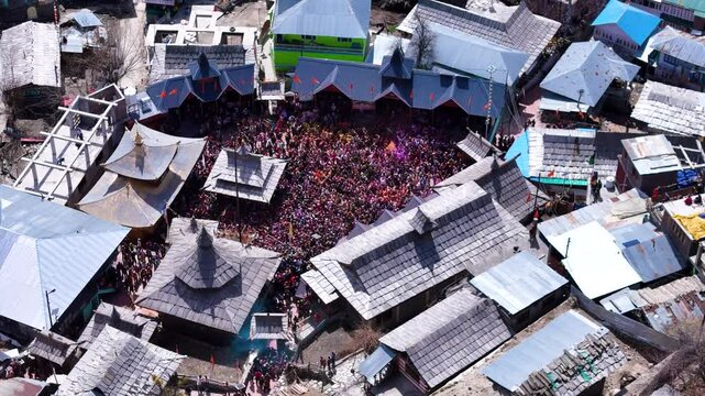 Aerial drone shot displaying the mesmerizing top-down view of Holi celebrations in Sangla Mandir, as the temple courtyard bursts into a riot of colors.