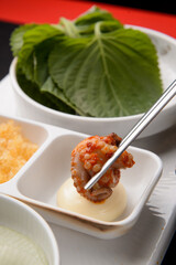 Dipping red seasoned octopus in sauce
