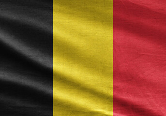National flag of Belgium waving with realistic fabric texture, vertical black, yellow, and red stripes.
