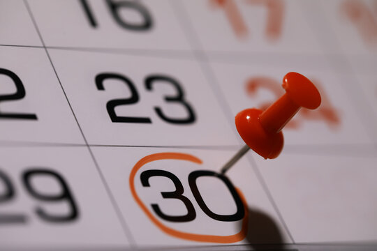 Marked Calendar Date with Red Thumbtack Highlighting Day 30 in Close-Up View