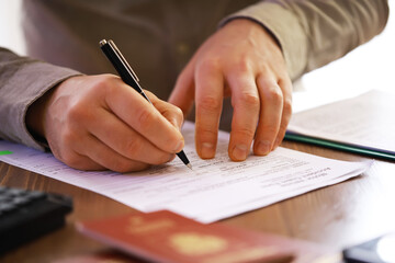 Close-up of Hands Signing Document with Passport on Desk - Legal, Official, Administrative, Office...