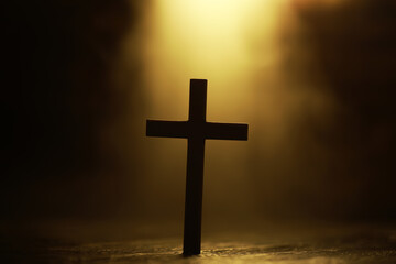 Silhouette of a Cross Against a Glowing Light Background in a Spiritual Setting