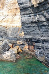View of cliffs and turquoise sea in Porto Venere, Italy. Entrance to cave. Panorama and nature. Sunny day and tranquility.