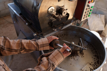 People inspect the drying and roasting of coffee beans in large metal vats - a blend of Arabica and Robusta for producing premium coffee with excellent taste.
