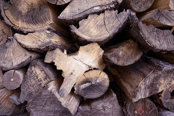 Chopped and stored firewood. Wood intended for heating in the fireplace. Wood texture. Cut and chopped wooden logs - Ecological heating.