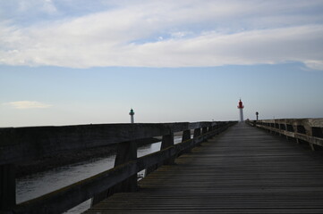 Obraz premium Atlantic Ocean low tide with dark wet shoreline and coastal houses — a calm seaside landscape typical of European Atlantic towns.