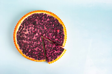 Large blueberry pie with a cut-off piece in close-up on a light background, kopi space