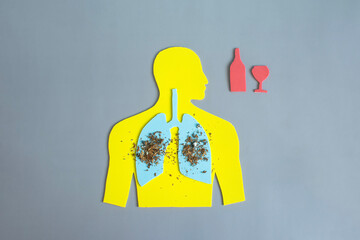 The silhouette of a man with highlighted lungs sprinkled with tobacco and alcoholic beverages is...